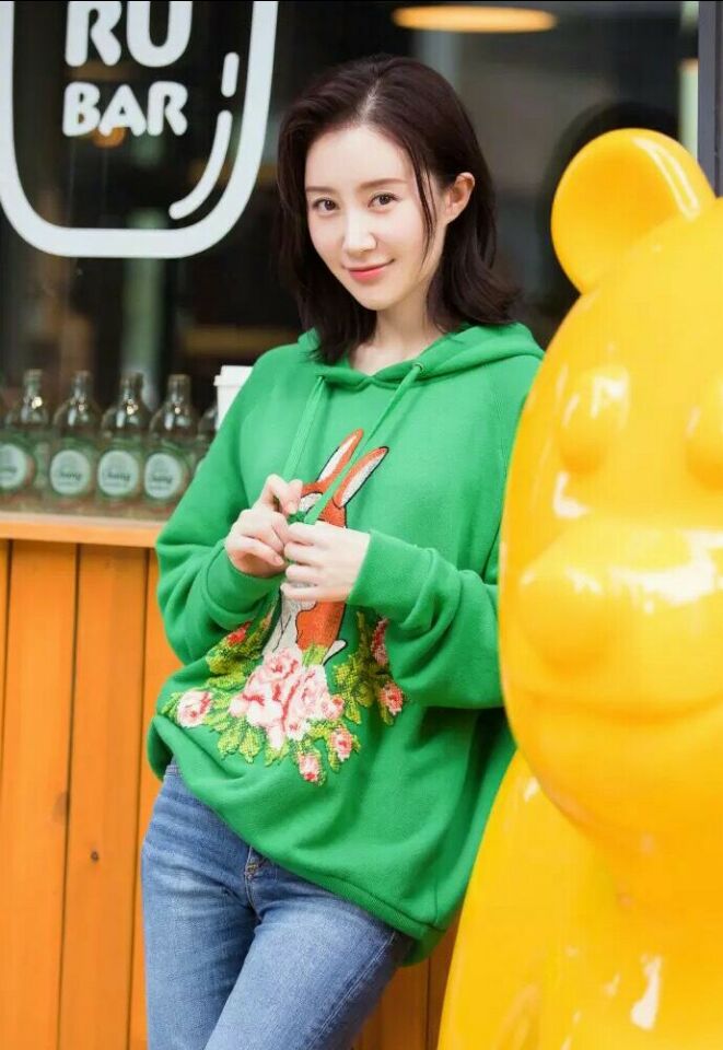 舒畅绿色卫衣配牛仔裤休闲活力,街拍表情丰富显演技