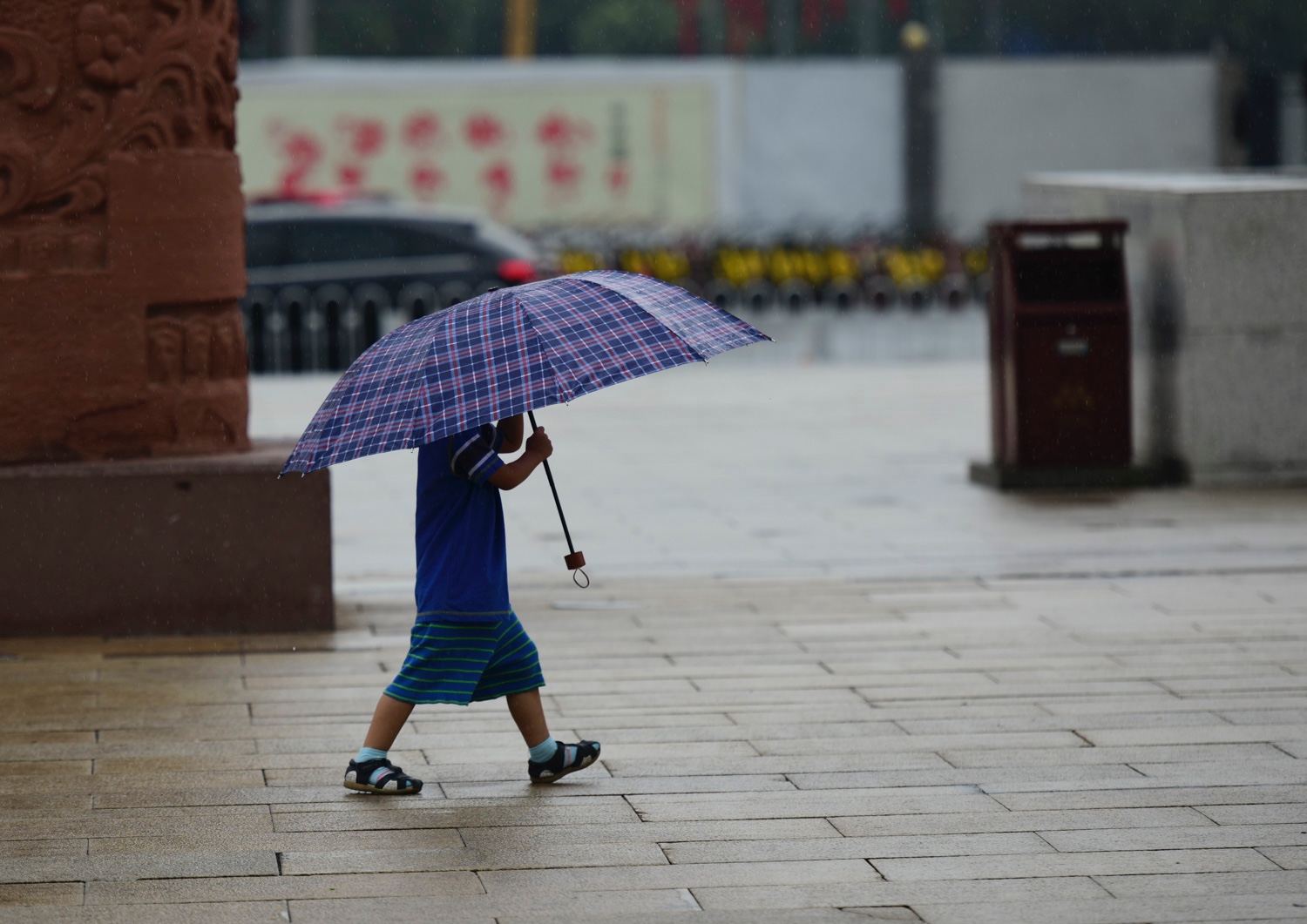 西安雨中老人撑伞等孩子睡醒 自己淋湿
