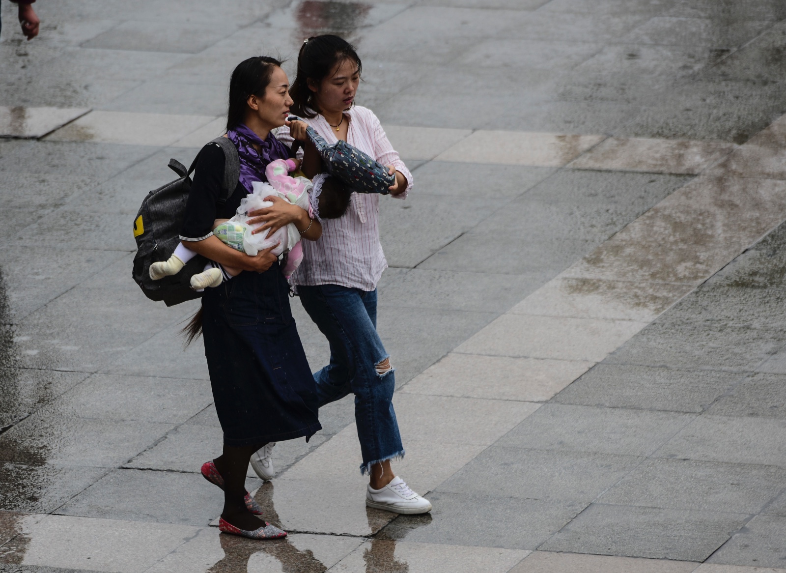 努力用手中的包为孩子遮雨