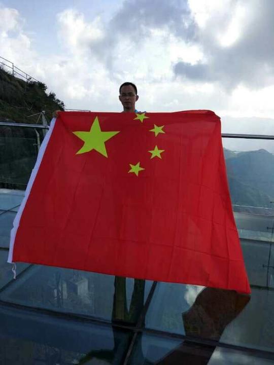 来自广州的几名客人手持一面长6米,宽5米的大国旗来挑战玻璃天梯.