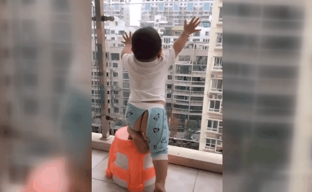 实拍: 8层高楼, 1岁小孩拿凳子扒阳台, 妈妈还在拍视频, 心真大