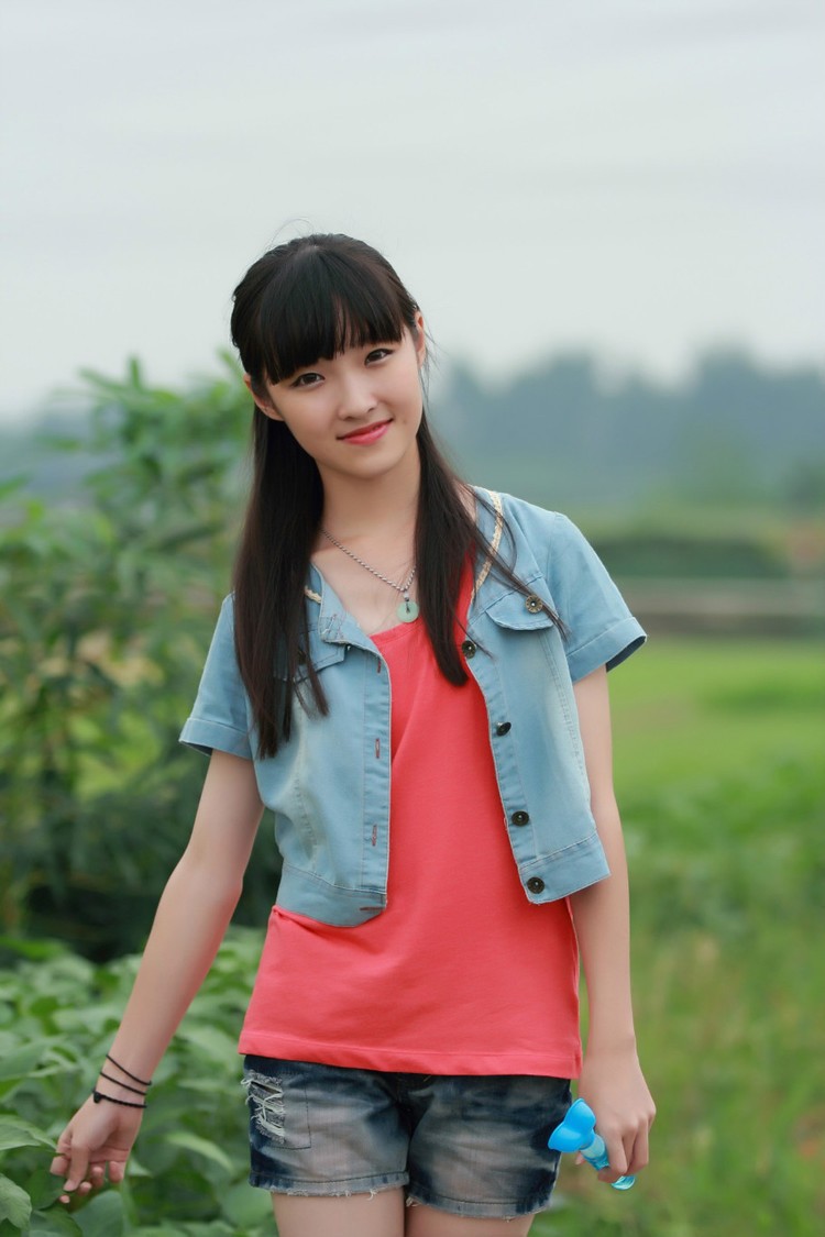 草地上一个青涩美丽笑起来脸上露出小酒窝的姑娘(多图)