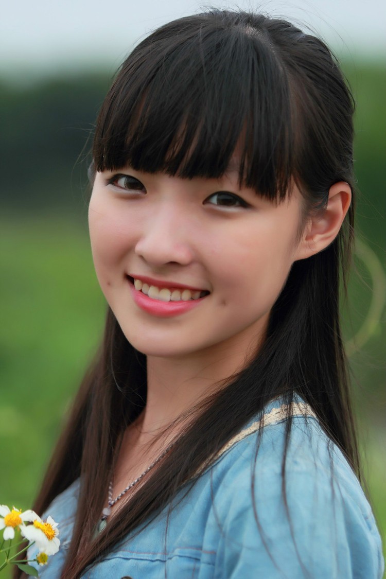 草地上一个青涩美丽笑起来脸上露出小酒窝的姑娘(多图)