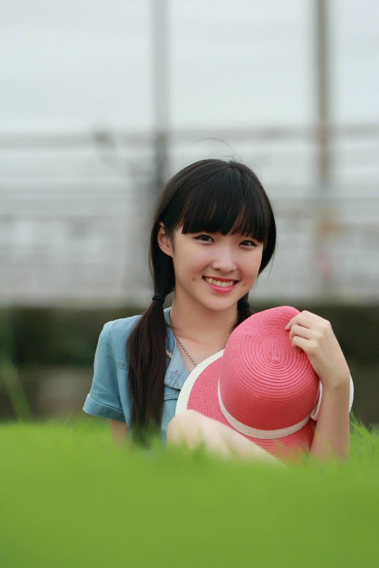 草地上一个青涩美丽笑起来脸上露出小酒窝的姑娘(多图)