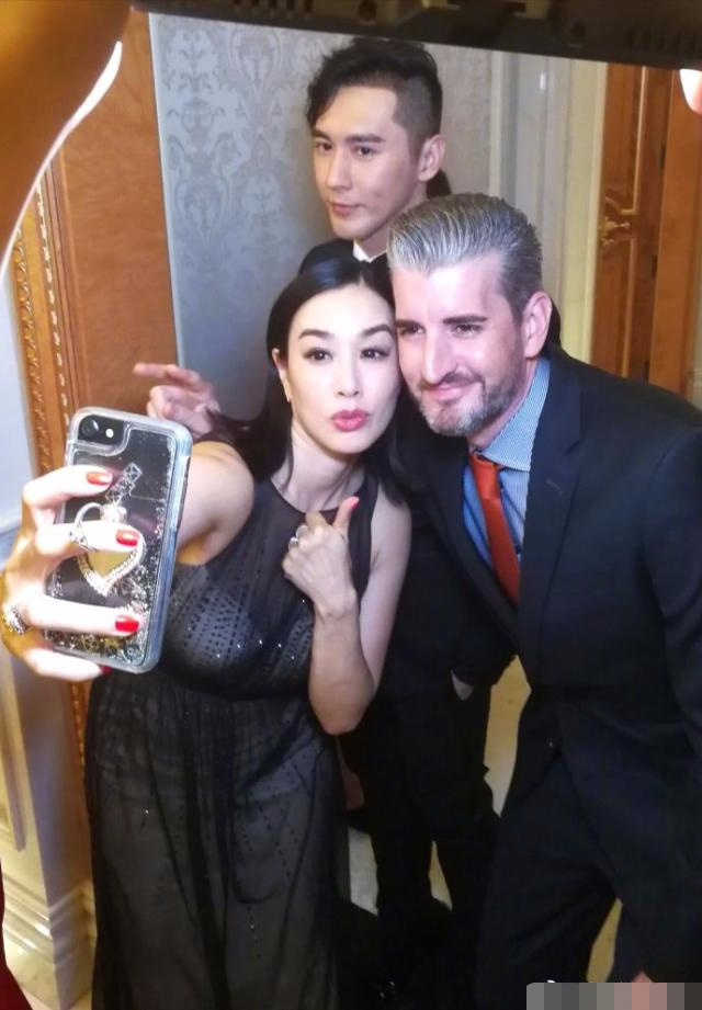 钟丽缇穿透视长裙让人眼前一亮,和老外自拍很自信