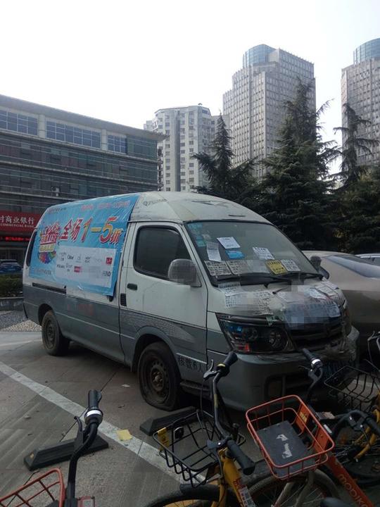 眼镜店拖僵尸车来宣传 小广告趁机乱贴"牛皮癣"