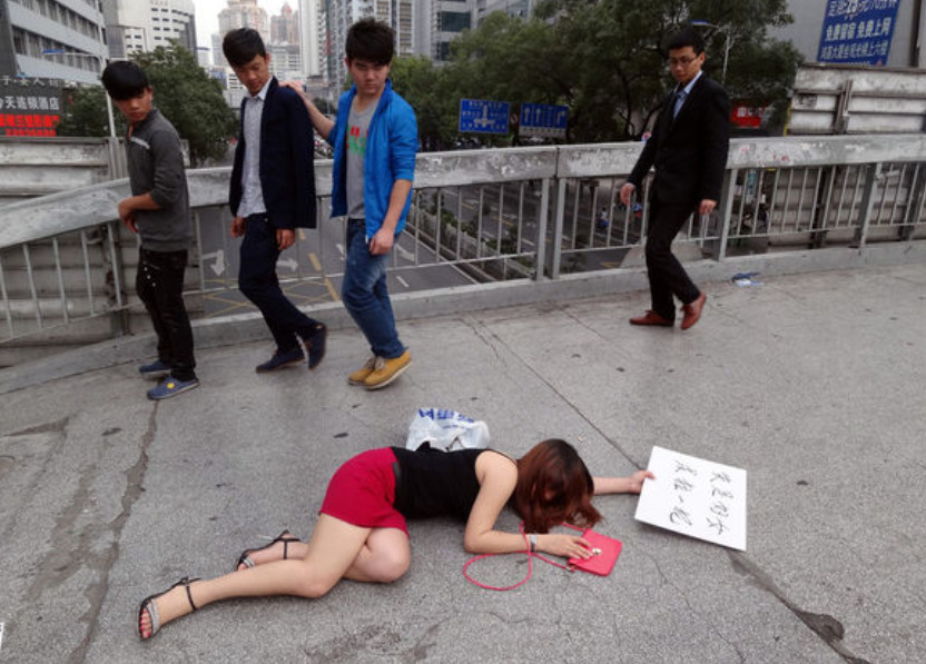 而尤其让人诧异的是,其手上有一个牌子上面写着"失足妇女,求拉一把"8