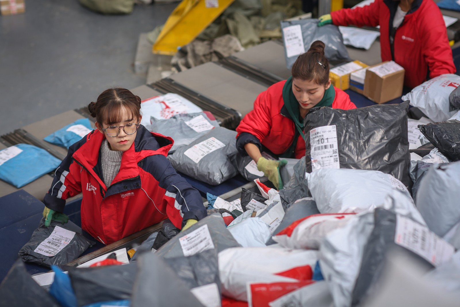 传送带自动分发到不同地区收集袋中的现代化自动分拣区,在快递分拨
