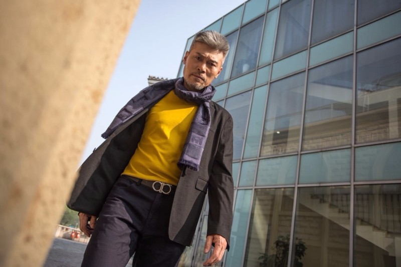 赵恒煊身着深色西服搭配蓝紫格围巾,明黄色内衣衬托的恰到好处,既明亮