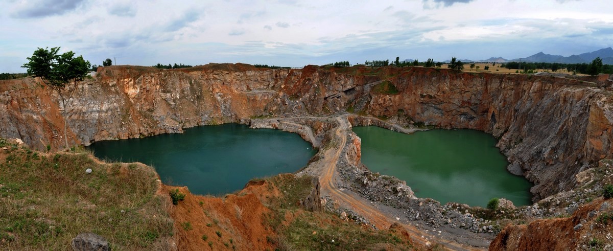 河南农民炸山取石挖出天坑 水面300米方圆水深30米游泳者络绎不绝