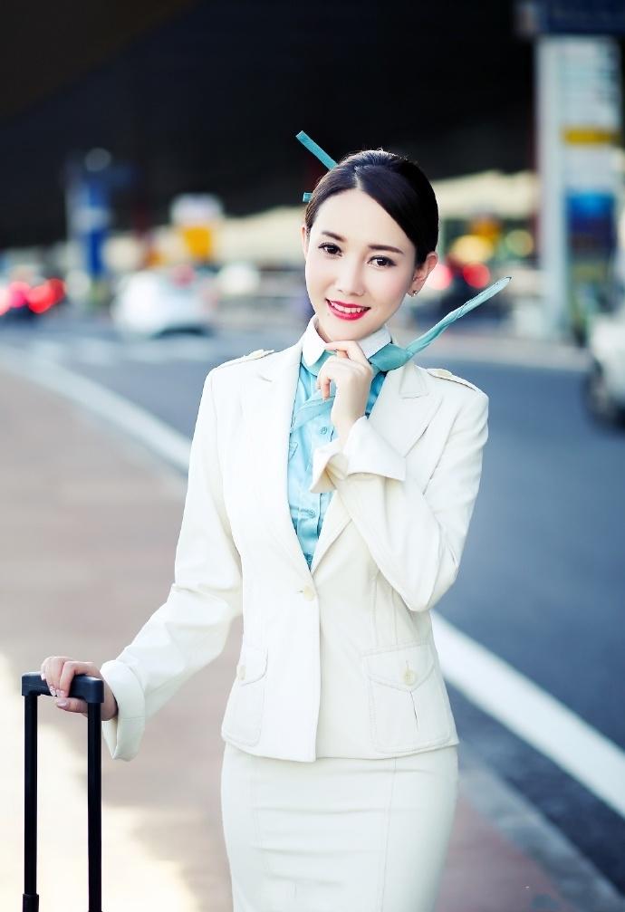 空姐扎起头发,利落的发型,穿着一身职业装,姿态奇美,明艳高雅,仪容