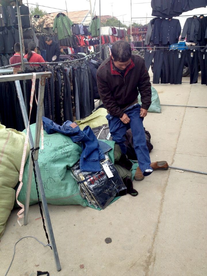 集市上,经营服装生意的最少有六七十个摊位,但几乎无人问津,赶集的人