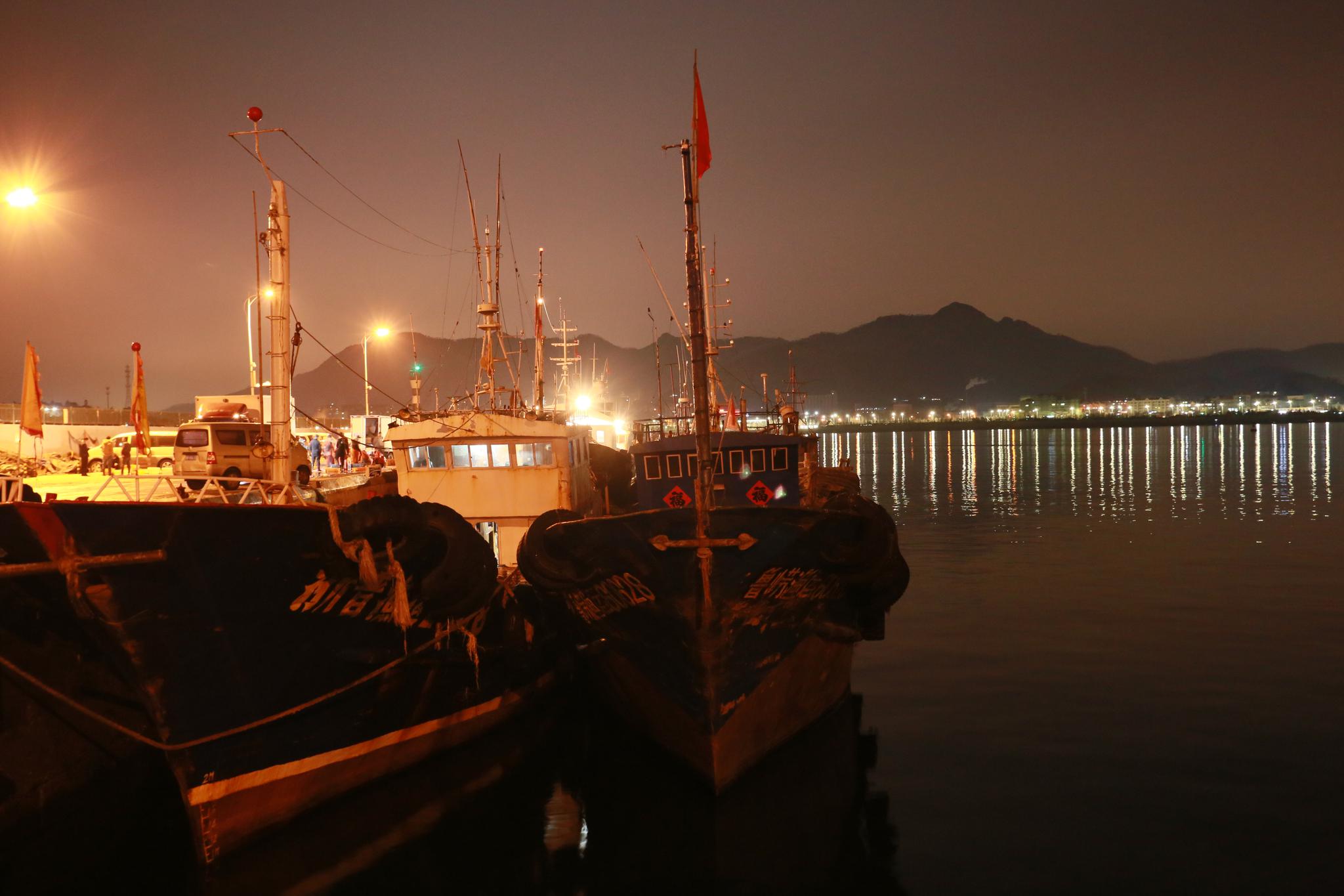 夜晚,美丽的崂山沙子口渔港码头,忙碌的人们.