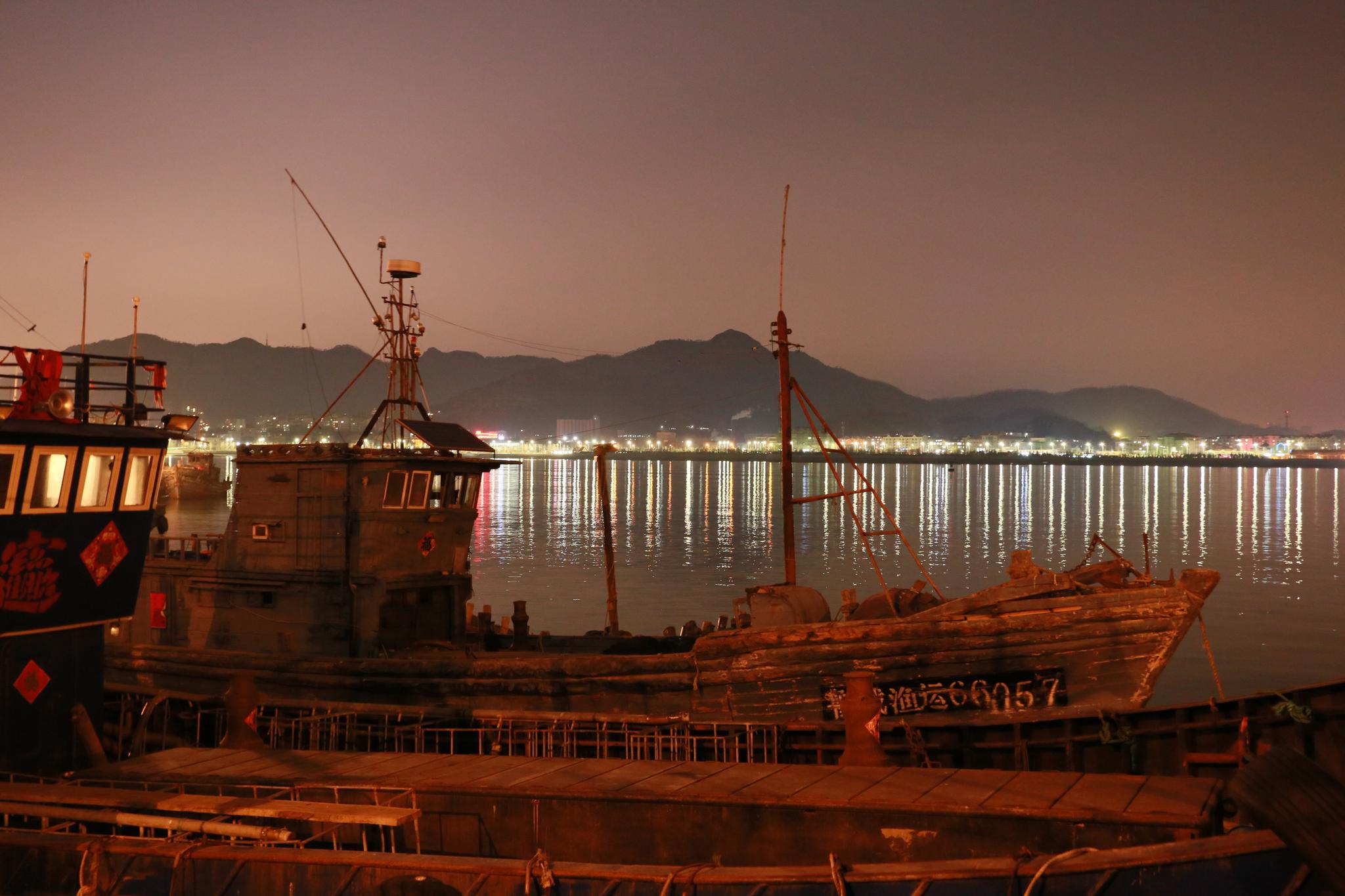 夜晚,美丽的崂山沙子口渔港码头,忙碌的人们.