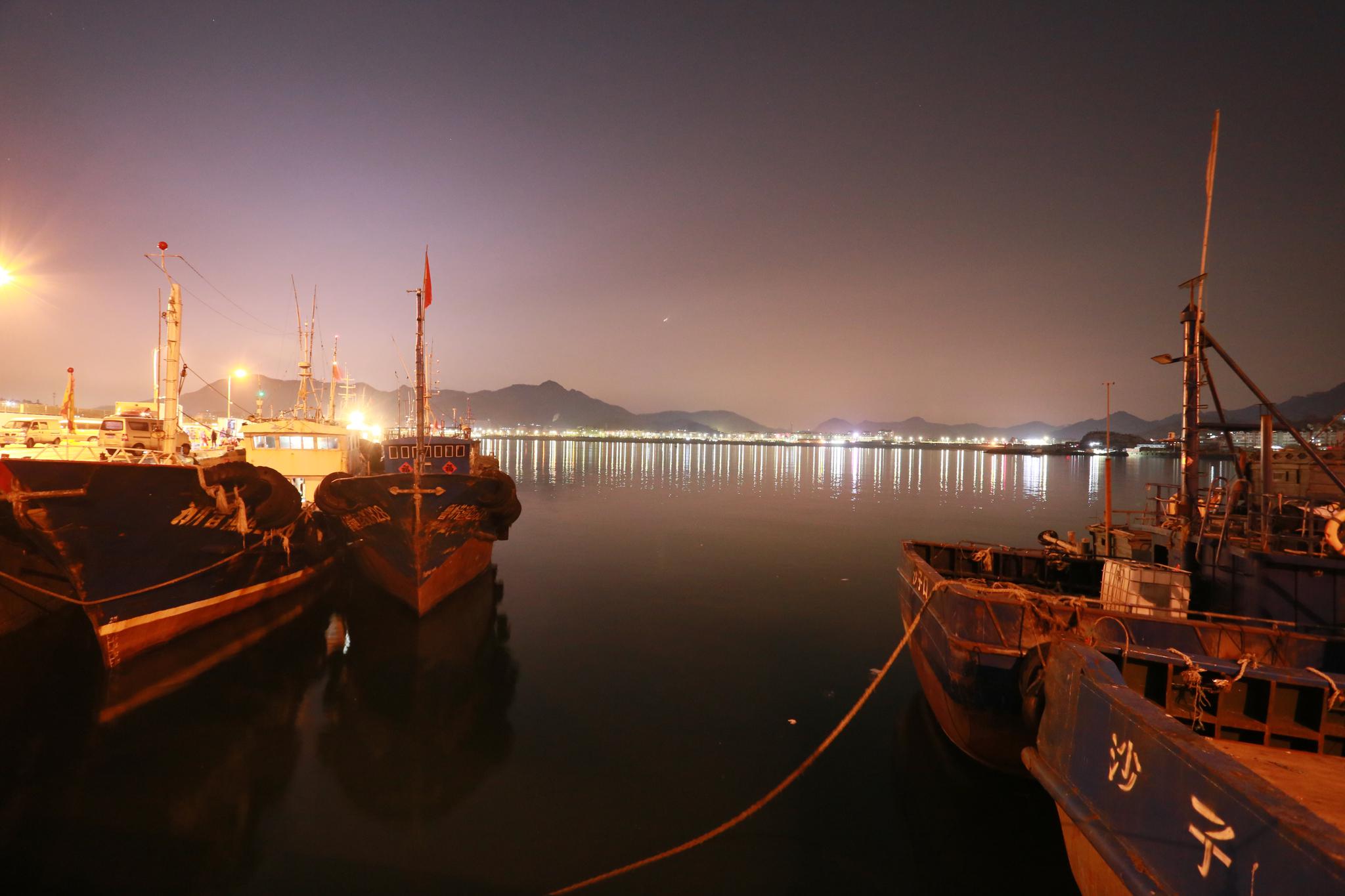 夜晚,美丽的崂山沙子口渔港码头,忙碌的人们.