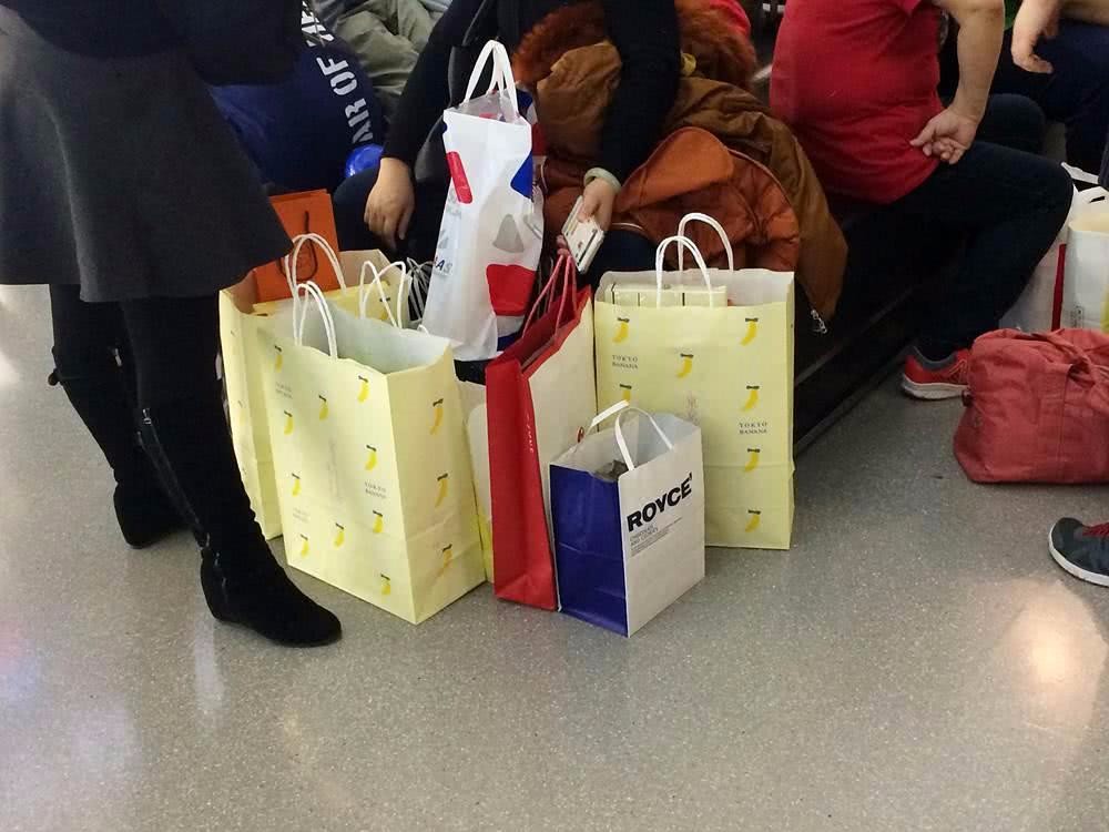 很多游客手里都拎着一堆购物袋.