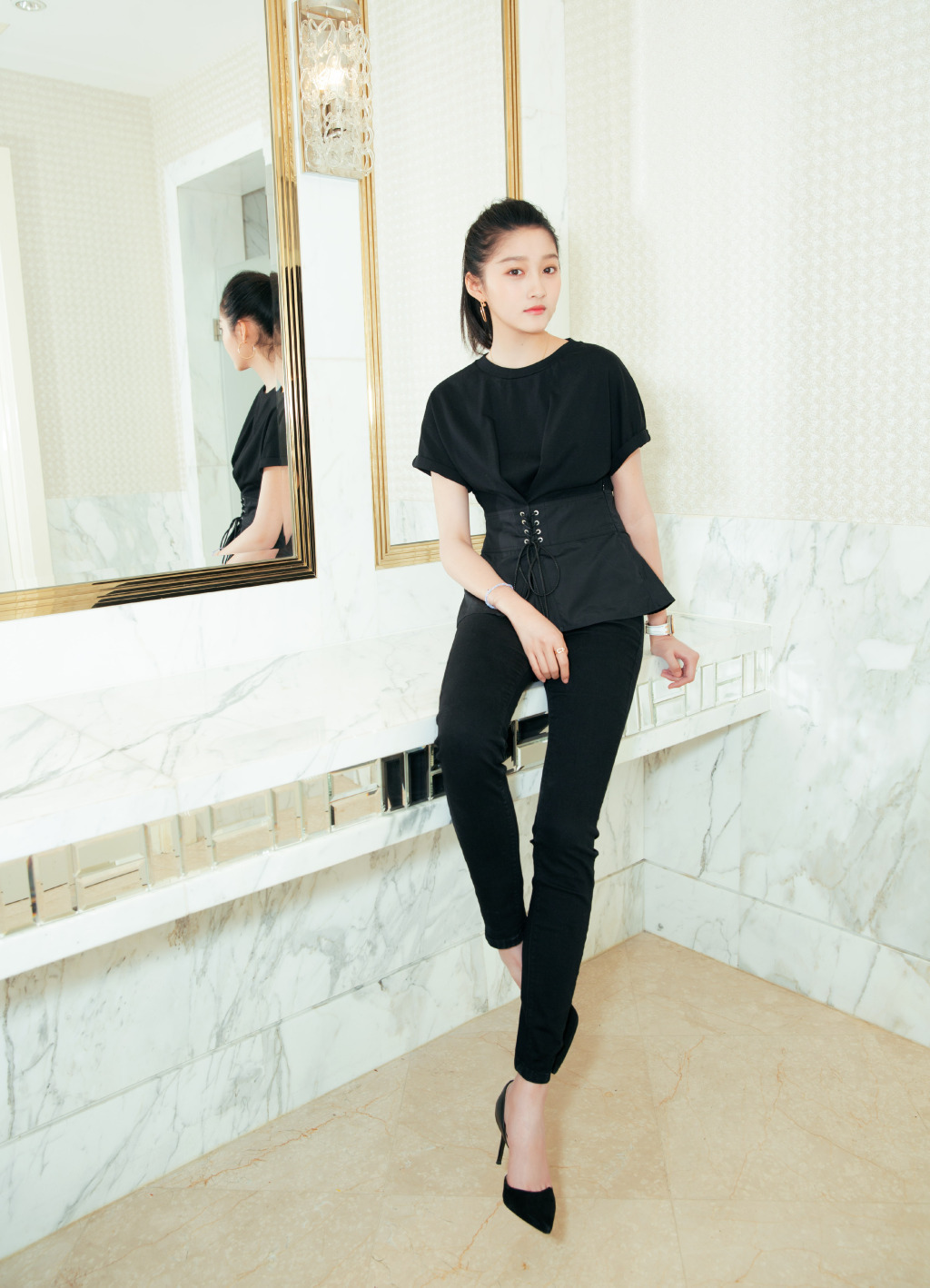 关晓彤身穿一款黑色上衣,搭配一款黑色长裤,脚踩一双黑色高跟鞋,看