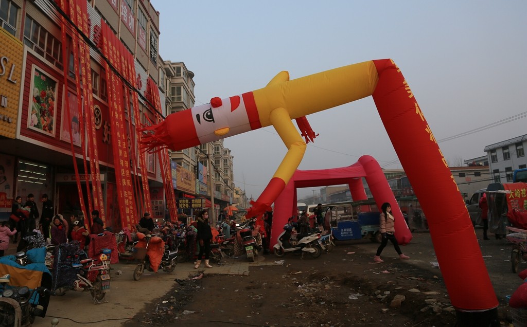 乡镇商店开张花300元雇用气球人门前拱手作揖和游客握手