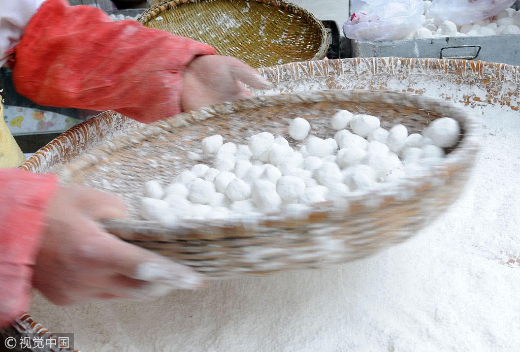 一家蛋糕店门口,面点师傅按照传统手工元宵技艺现场制作的元宵.