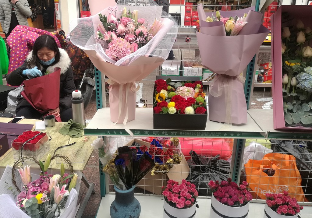 情人节鲜花销售摊位鳞次栉比 一束99朵紫色的玫瑰猜猜要多少钱?