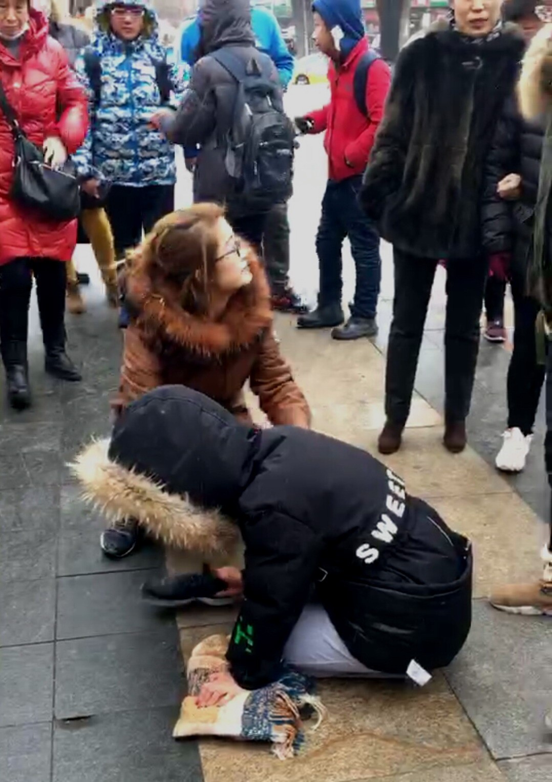 女孩街头跪地哭嚎引围观,怎成想竟是为了拉观众