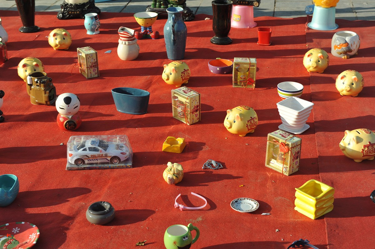 图为一个套圈摊位的地上摆放的奖品.