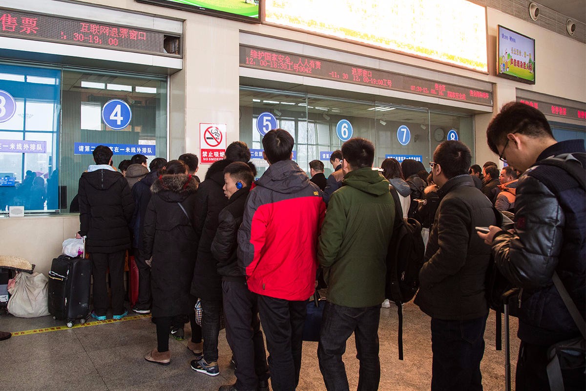 一些刚取出票的旅客无奈在互联网退票窗口排队,等待退票.