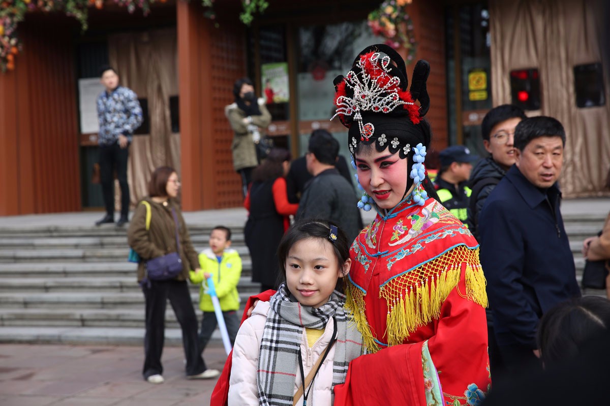 新春巡游民间艺人站街头 游客市民争相合影