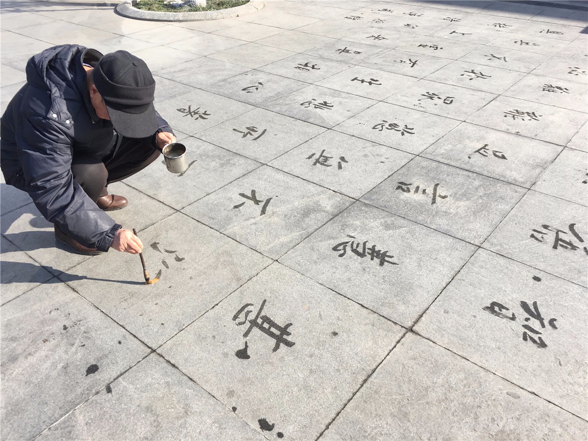 老人扎堆练地书 即使众人围观也如入无人之境