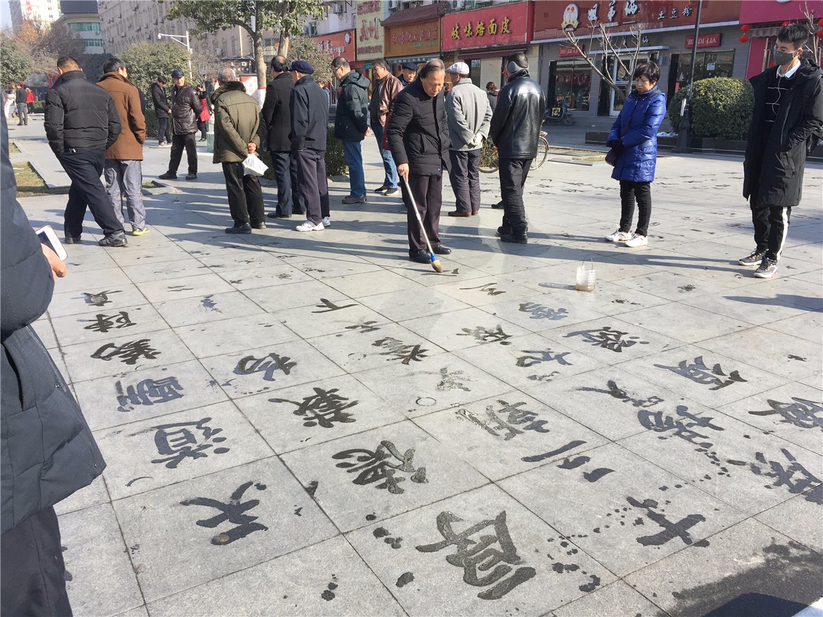 老人扎堆练地书 即使众人围观也如入无人之境