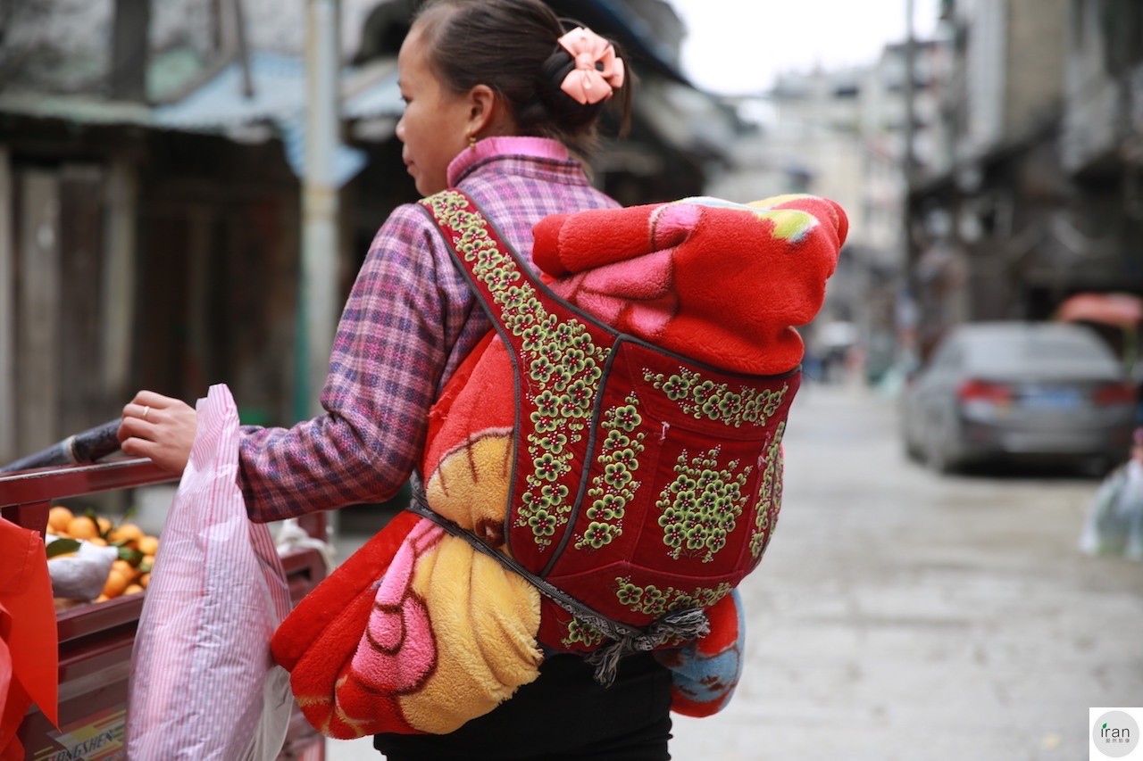 妈妈背着孩子做饭洗衣干活,看着都累,只为这个暖心原因