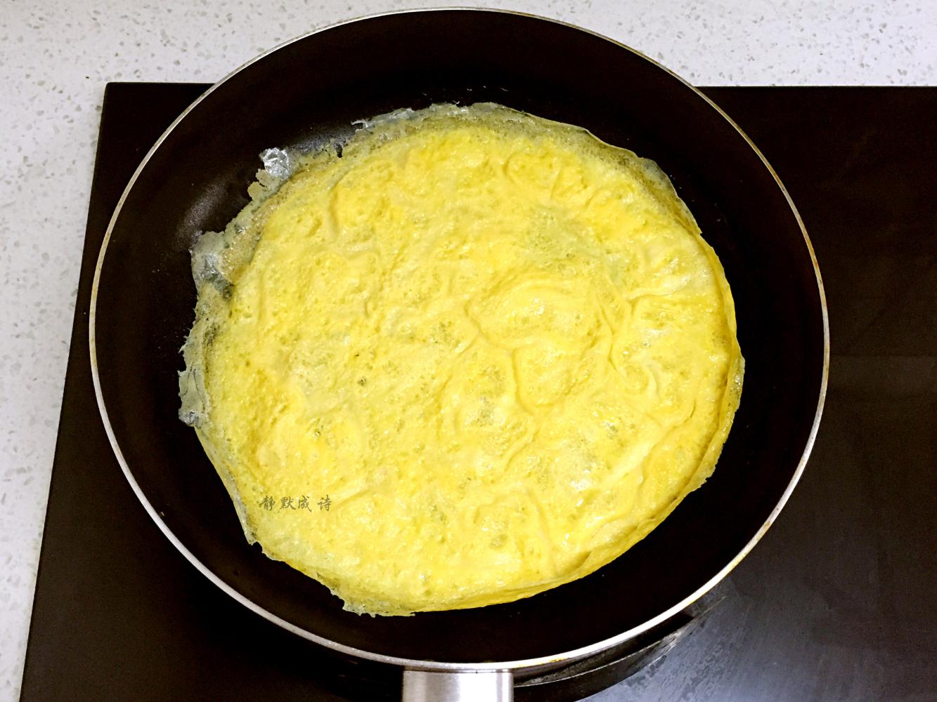 5,把煎好的蛋皮放在案板上,铺上拌匀的蔬菜肉馅儿,铺平整,要均匀而且