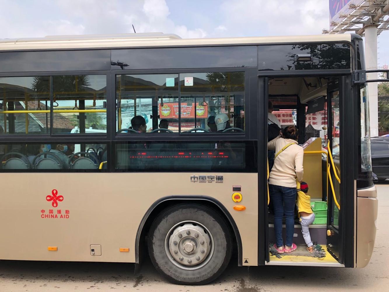 金边街道上行驶着的来自中国援助的公交车.