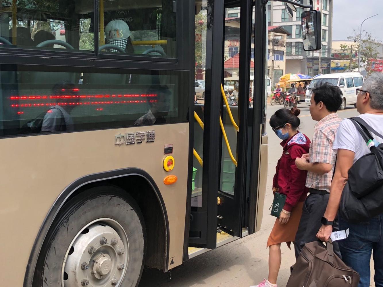 排队等待上公交车的金边市民.