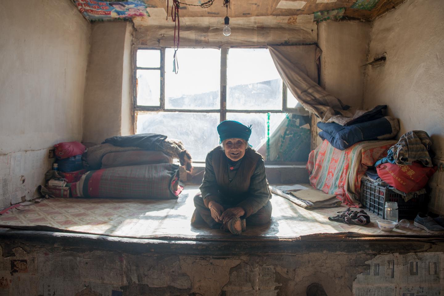 农村八旬老太独居土屋老房, 屋里没有电视, 每日穿着鞋在炕上呆坐