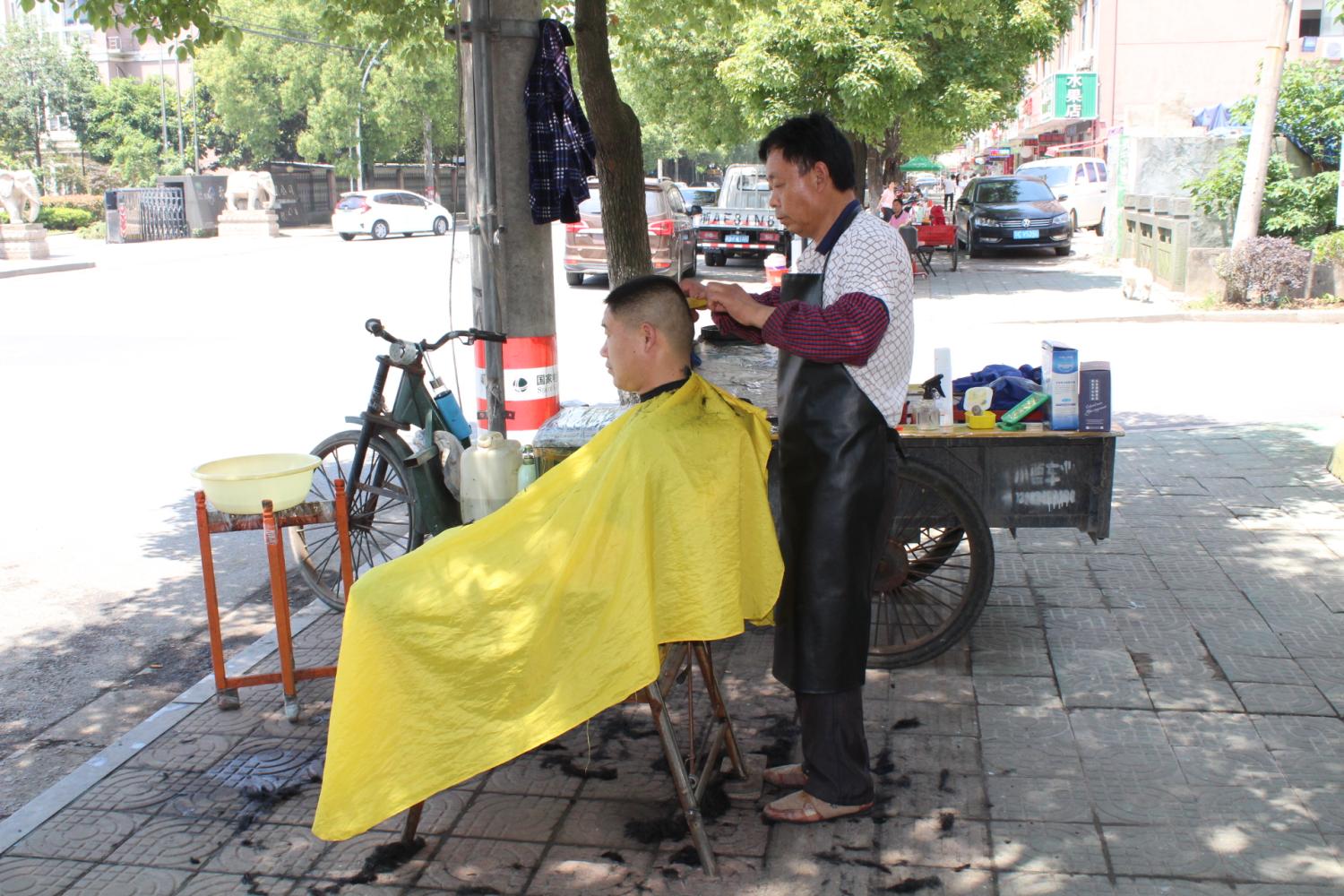 简易露天的街头理发摊, 十元剪一个, 服务甩理发店几条街