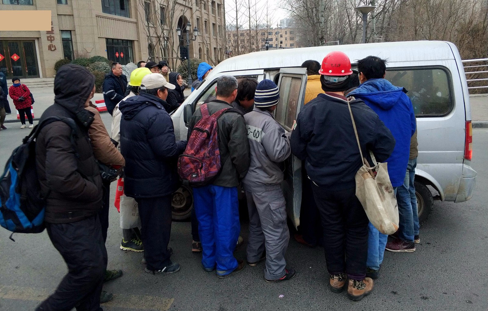 图为:在青岛一灵活劳务市场上,多名工人在询问雇主工作内容,薪水.