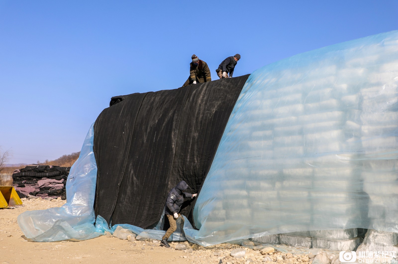 艰苦!农民工给万吨冰垛盖棉被 稍有不慎就摔骨折