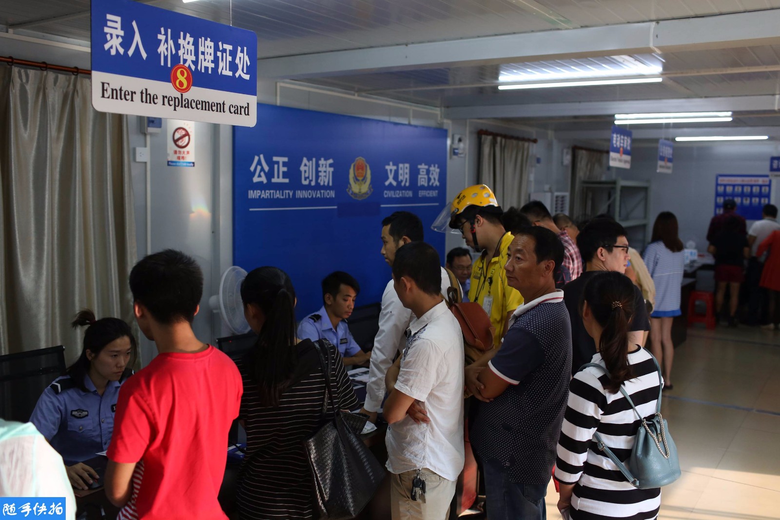 车管所中,不少等待领取车牌的市民在排队等候.