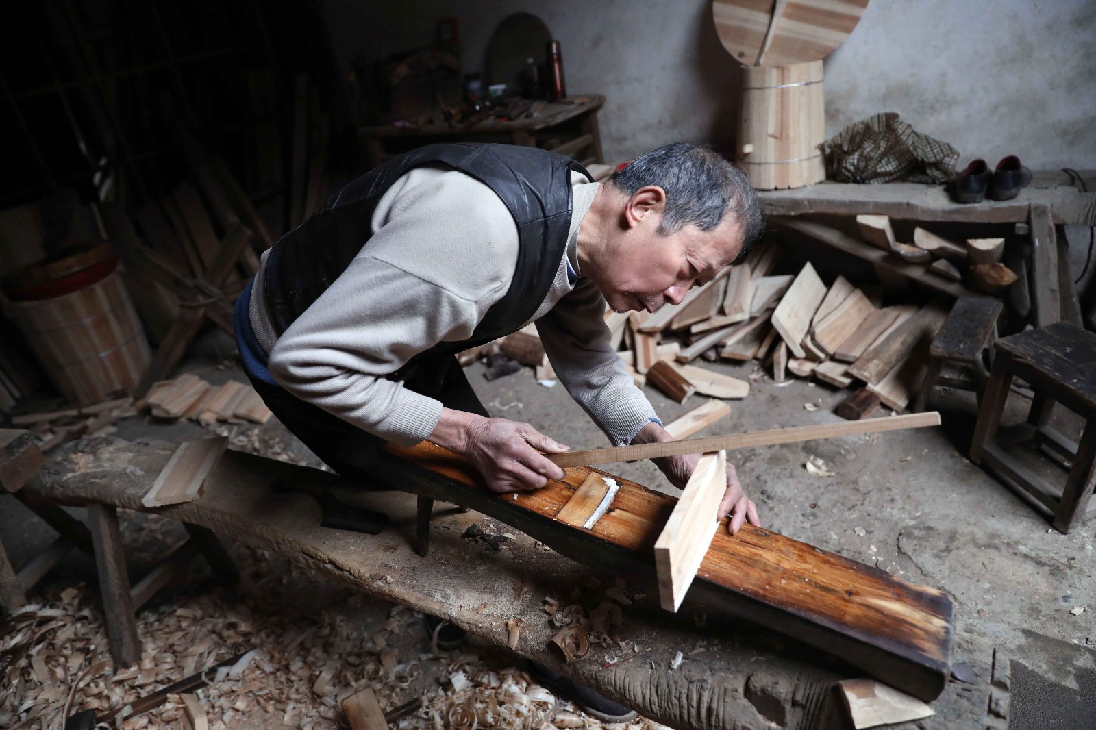 1月11日,在浙江常山县芳村镇的古巷里,67岁的箍桶匠汪家荣认真检查刚