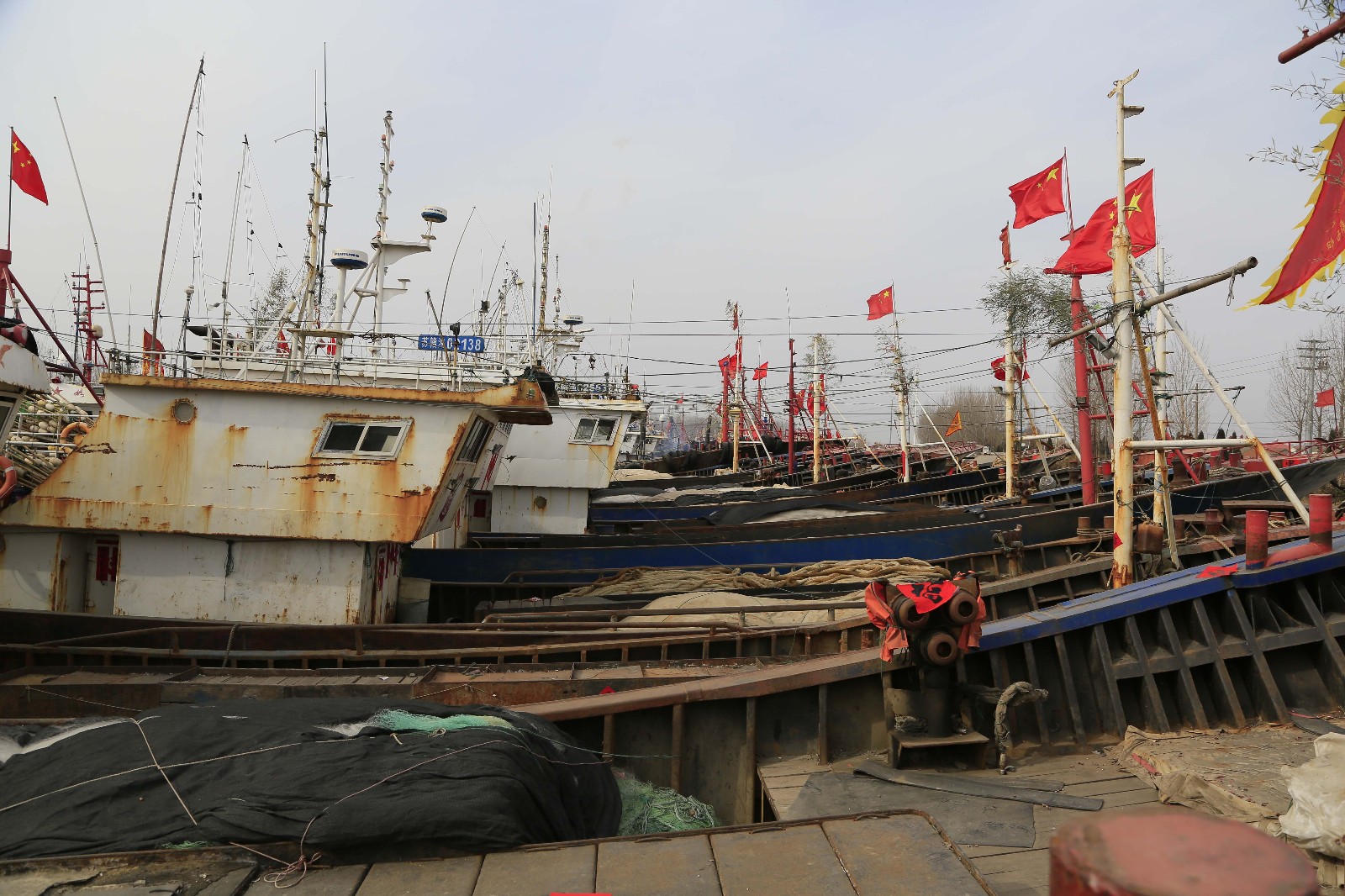 狗年除夕,不到十点钟,好多家渔民家的船上都悬挂着红旗,对联也早贴好