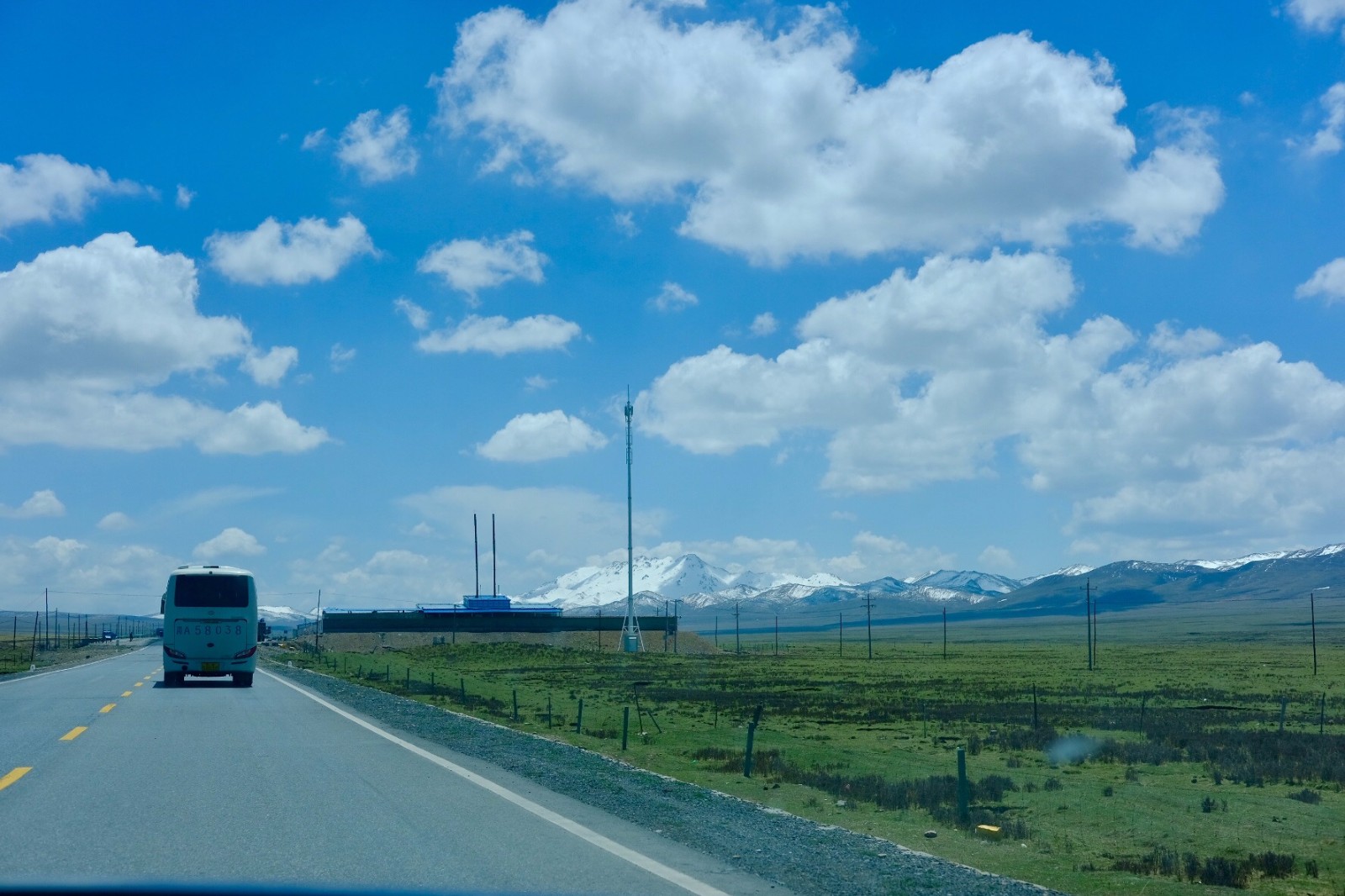 远眺蓝天白云侧面就是祁连山脉在这样的路上开着车是一种享受