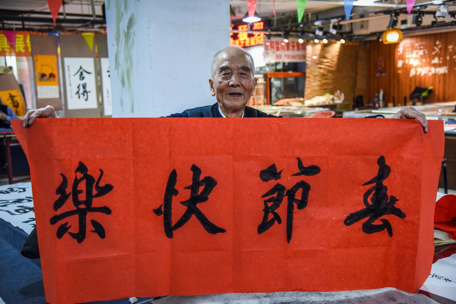 今年92岁的老人李金波是长春一位书法家,在长春市某地下商场摆摊写