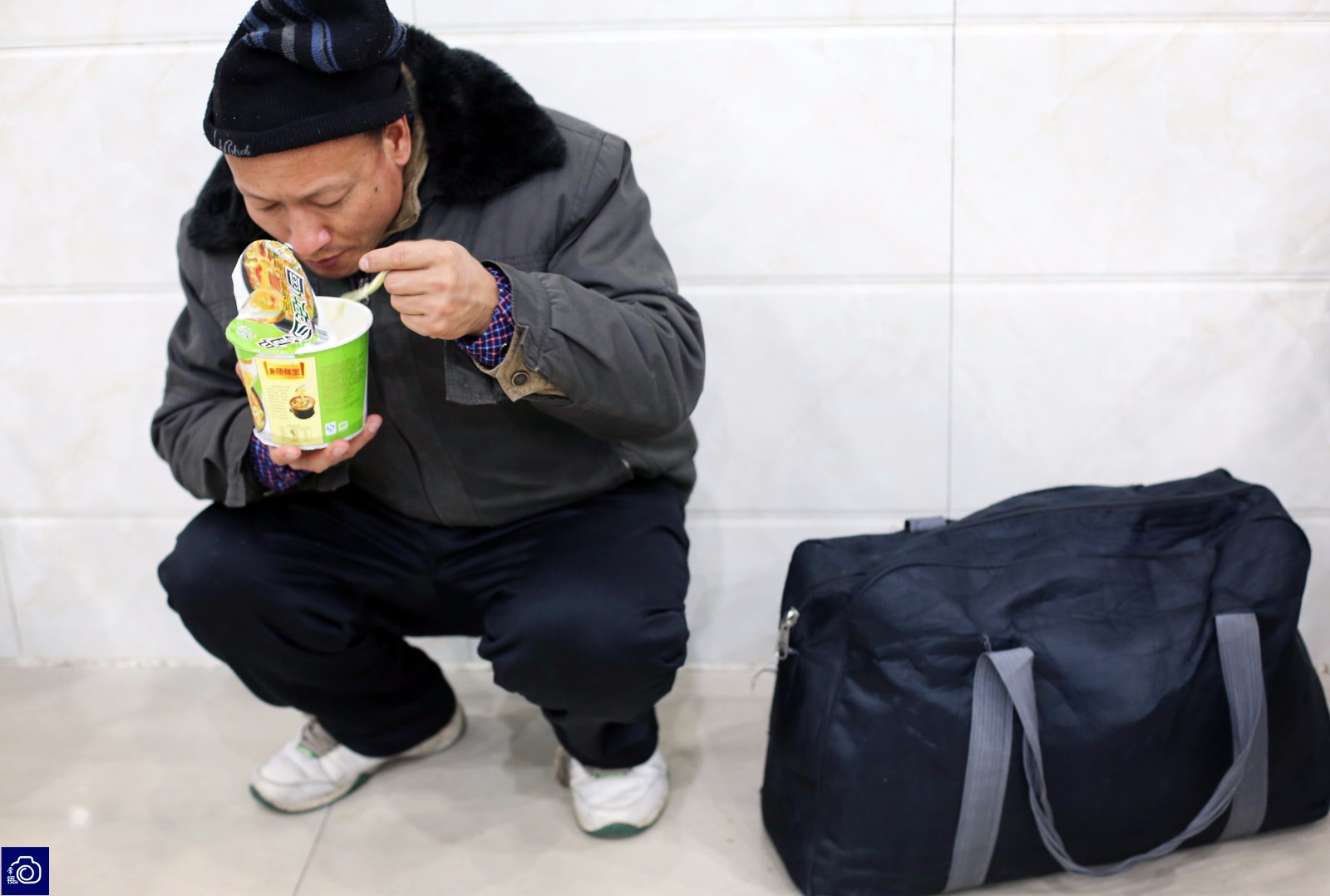 一名男子蹲在角落里吃面时的场景让人动容.