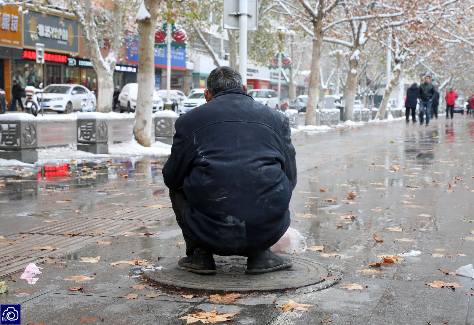 洛阳的最低气温达到了零下10度,西工区周王城广场附近,两名男子轮流蹲