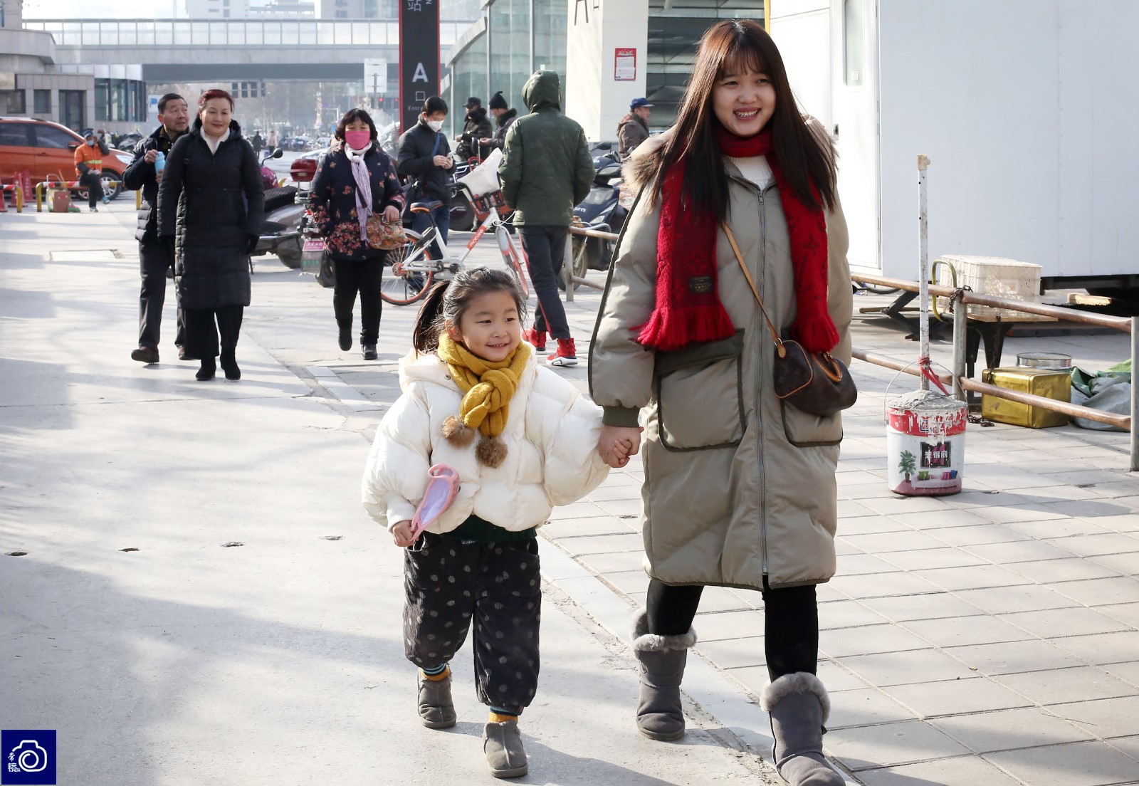 花园路附近,一名大人领着孩子趁着天气不错外出玩耍.
