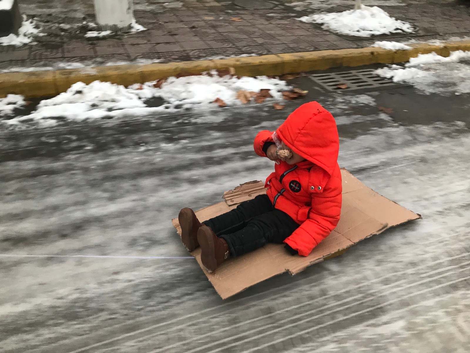 走进看清,自制的滑雪板是用一个塑料桶盖拴上绳子,担心孩子坐在上面