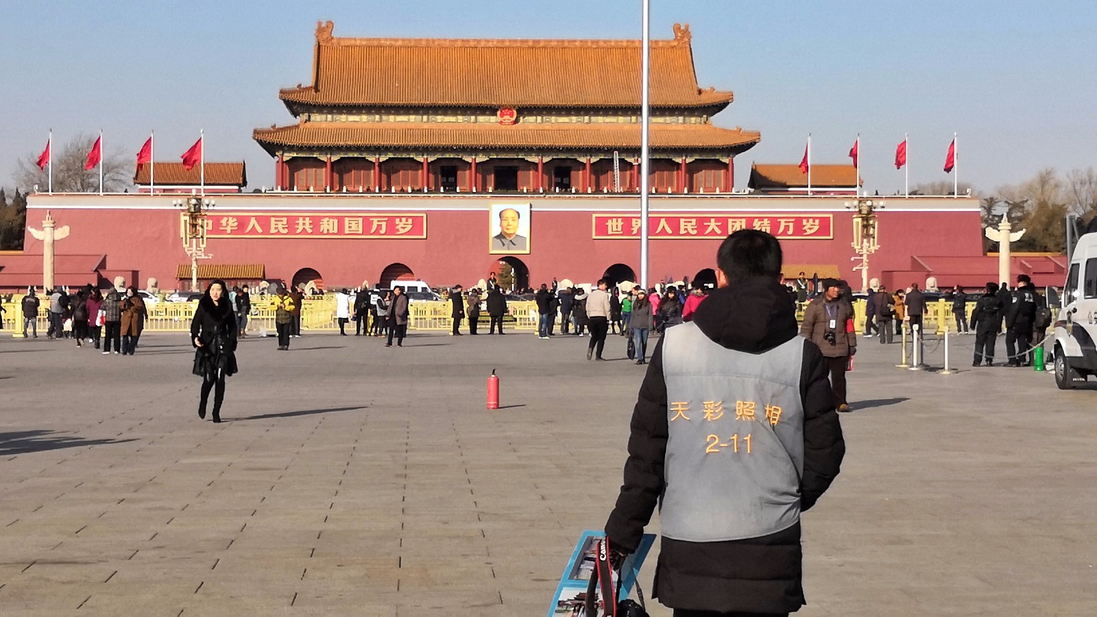 天安门广场上，寒风中给游客拍照的摄影师生意冷淡，却依然在坚持