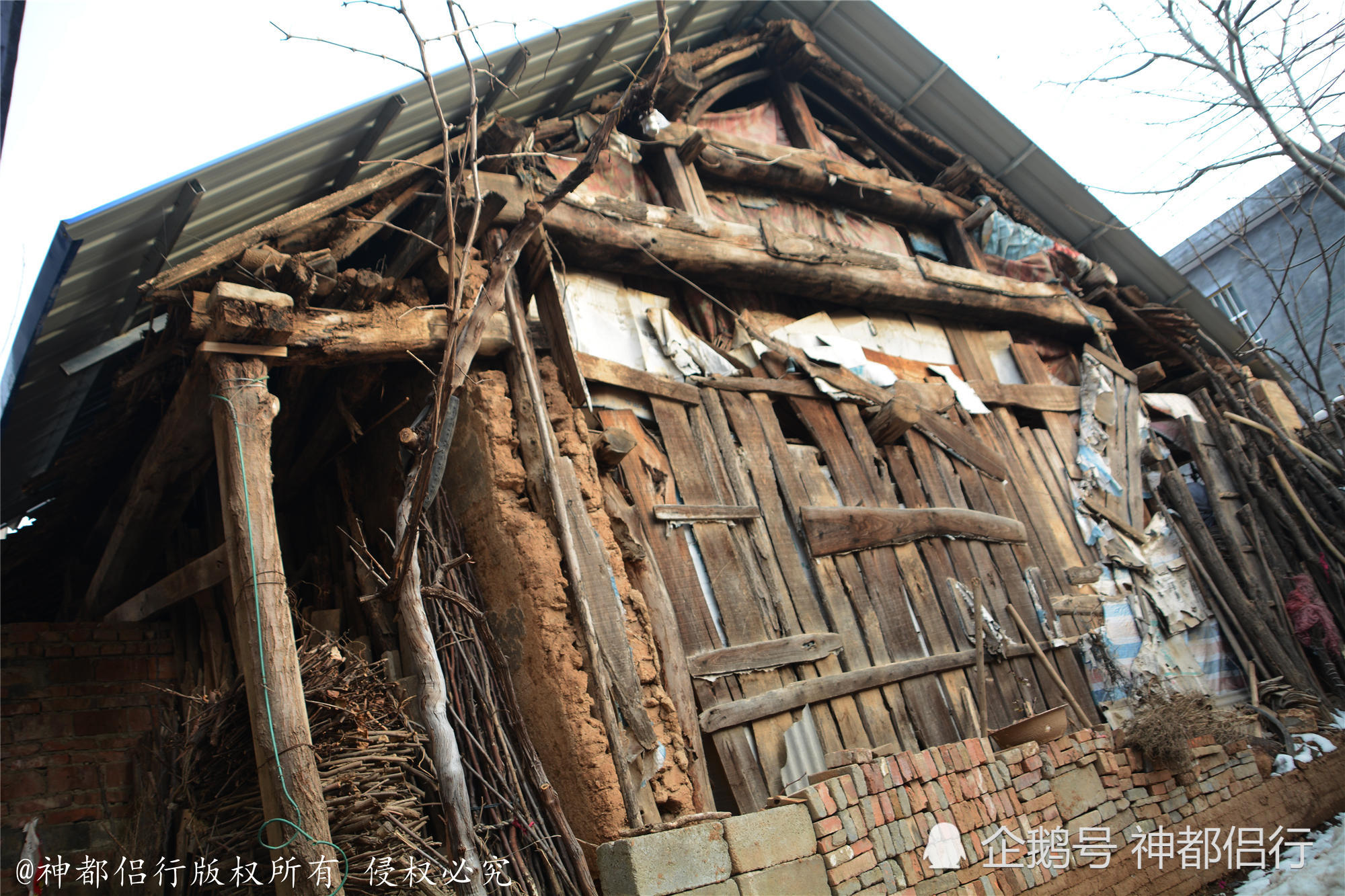 图为西侧的山墙已经完全垮塌掉了,李宗育用一些木头进行简单的封闭,用