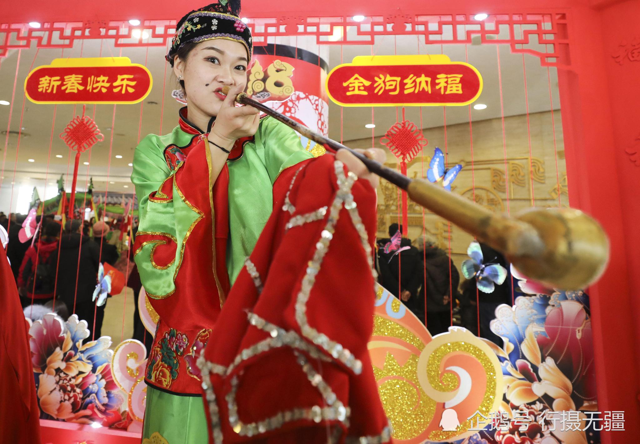 美女嘴里叼个大烟袋扮相花哨引众人的围观